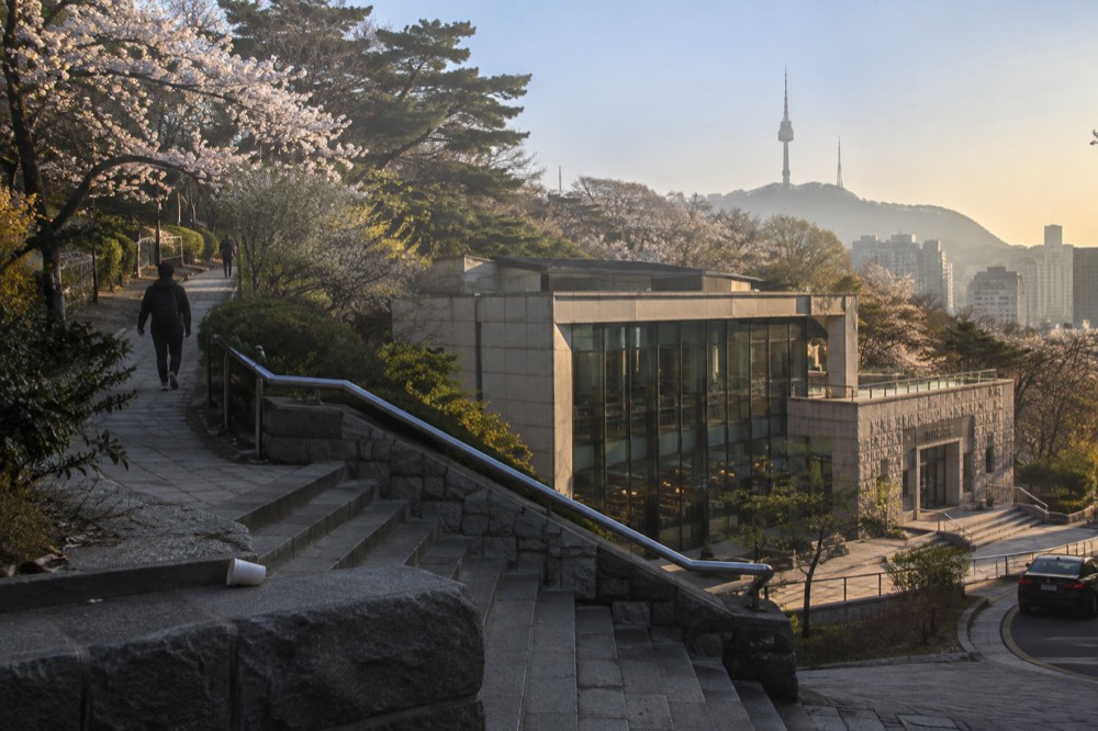 Morning light falling across the Namsan slopes and the Seoul skyline in the distance