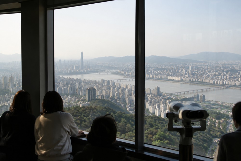 City apartment blocks and office towers under a wide sky seen from a high observation deck