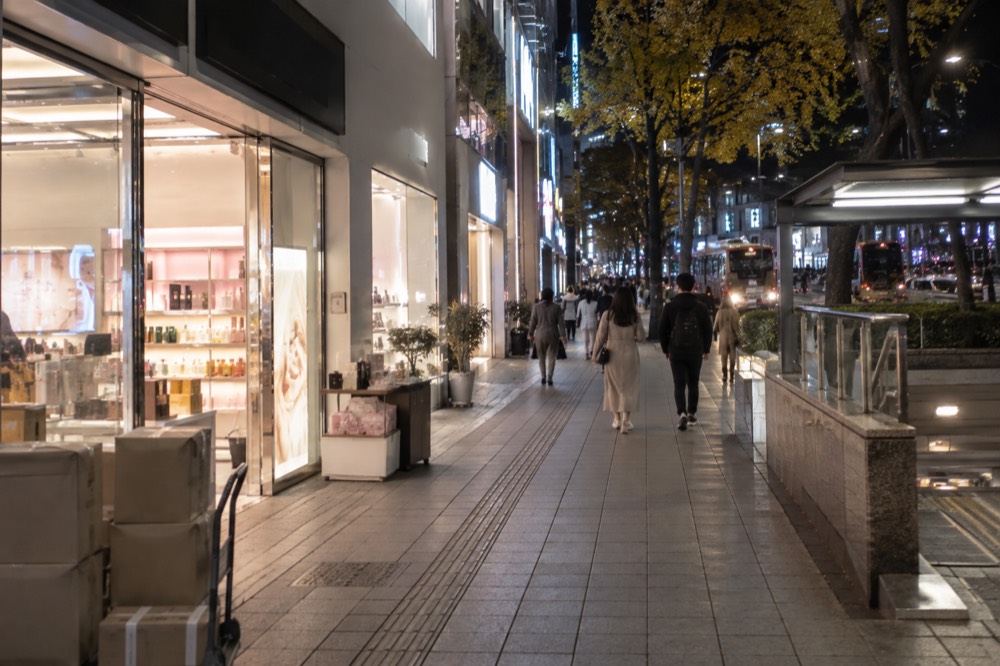 Rows of cosmetics shopfronts with bright signage along a Myeongdong street