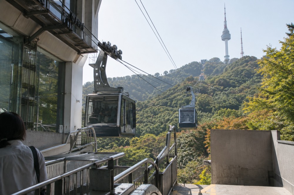 Cable car cabins arriving at the hillside base station above Myeongdong