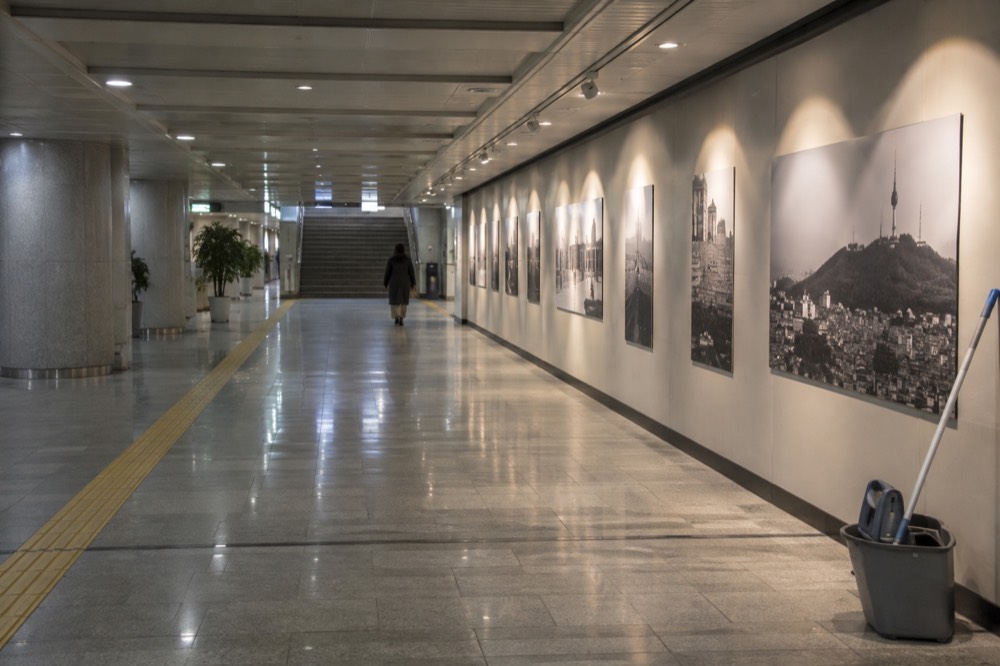 A modern underground cultural passage with lit exhibition walls and a walkway