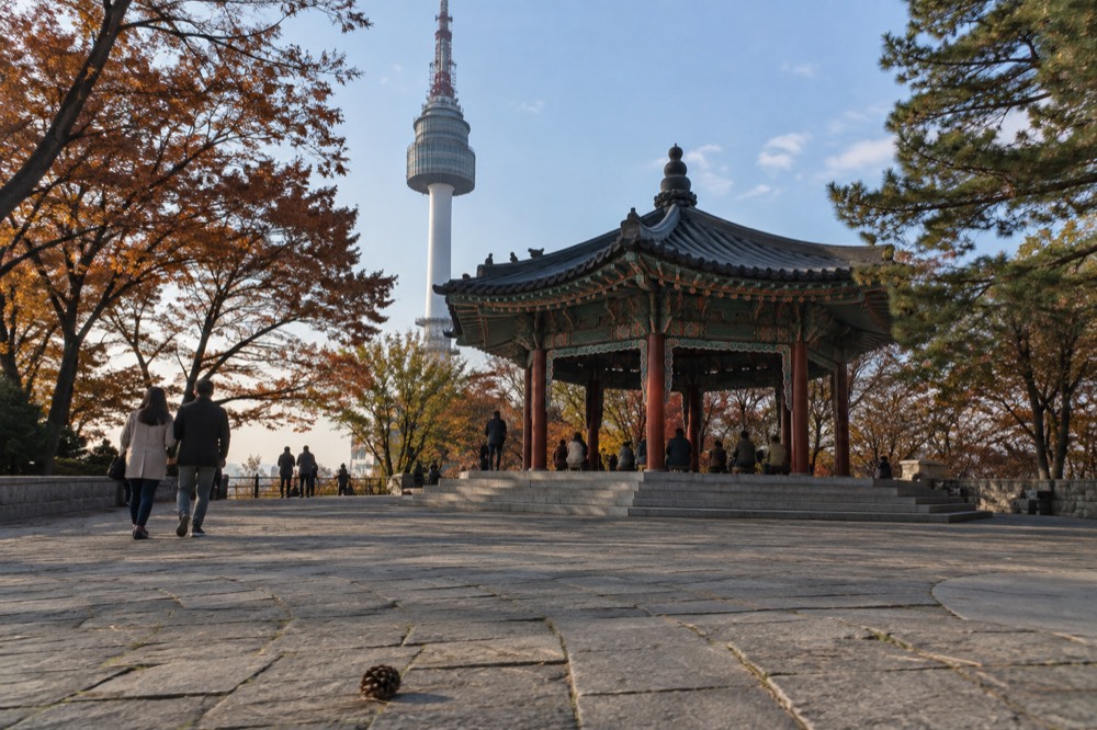 The summit plaza at Namsan with N Seoul Tower rising above tiled terraces and pine trees