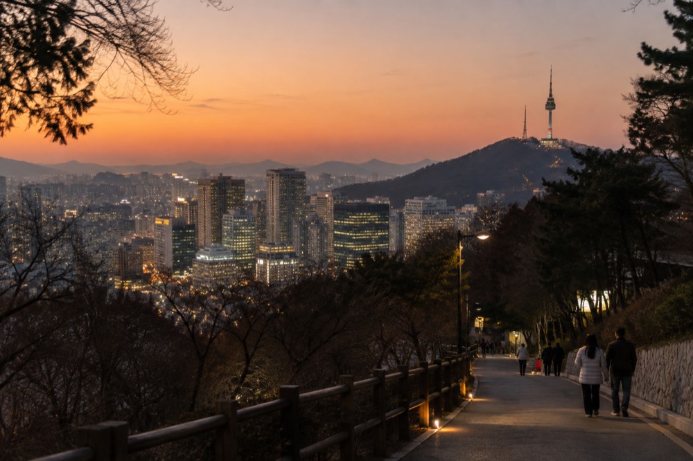 Modern hotel towers and office buildings in Seoul seen across a cityscape at dusk