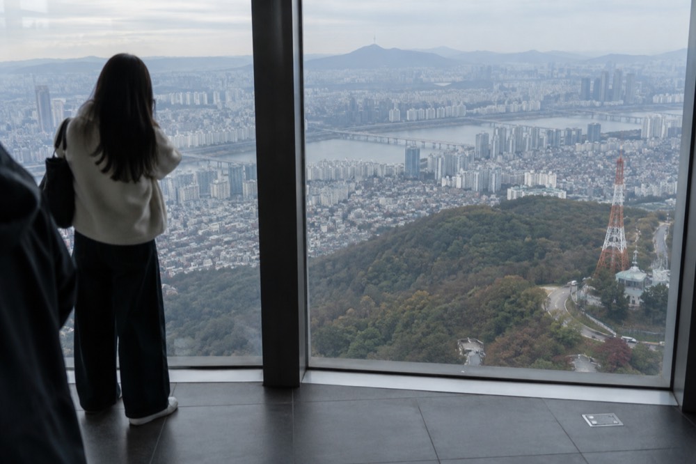 Observation deck interior with floor to ceiling windows overlooking a sprawling city