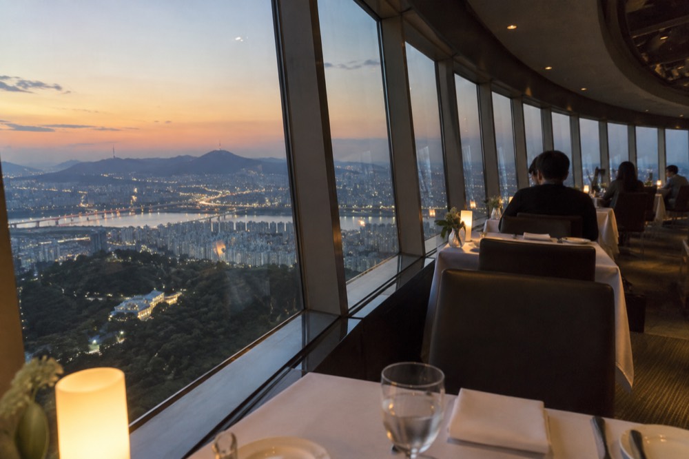 Elegant rotating restaurant interior with tables beside panoramic windows