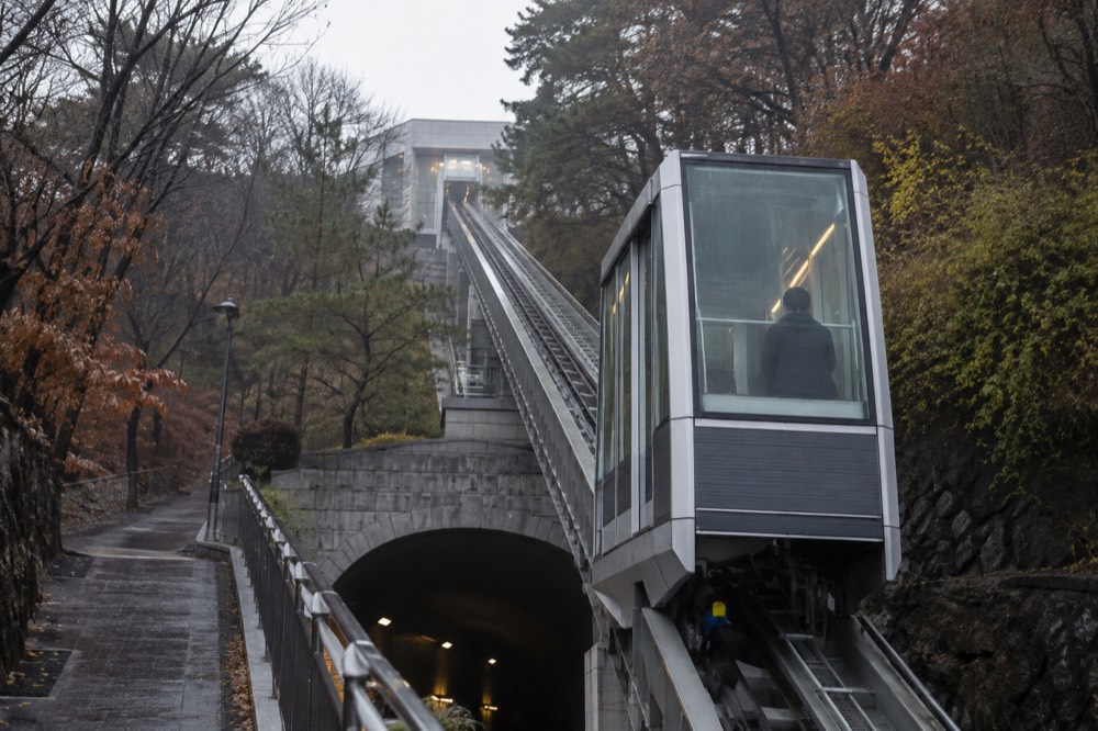 The glass-walled Namsan Ormi inclined elevator on its track between the tunnel and the cable car station